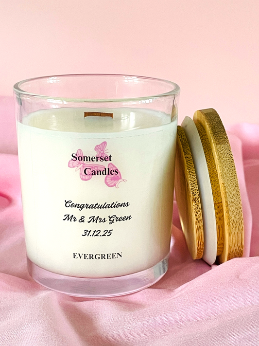 Personalised candle with a wooden lid on a pink background