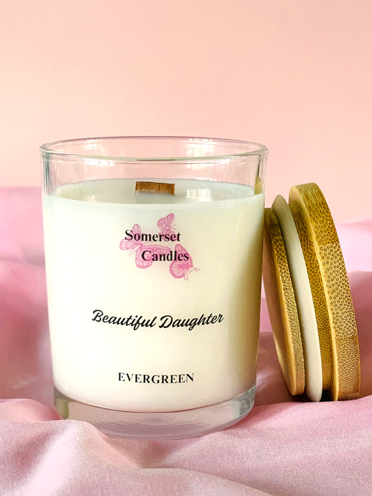 Somerset Candles 'Beautiful Daughter' candle with a wooden lid on a pink background