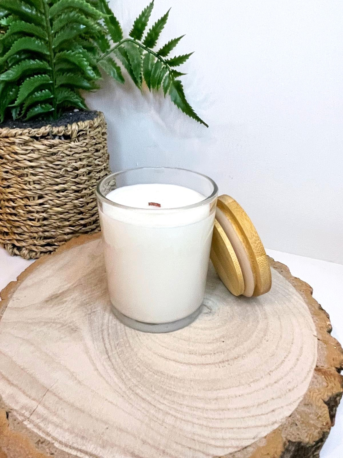 White soy candle in a 7oz clear glass jar with a natural wooden lid. The candle is made from a soy-coconut blend and a variety of fresh fragrances. The candle has no label. Clean, minimalist design ideal for gifts, home decor or self-care.