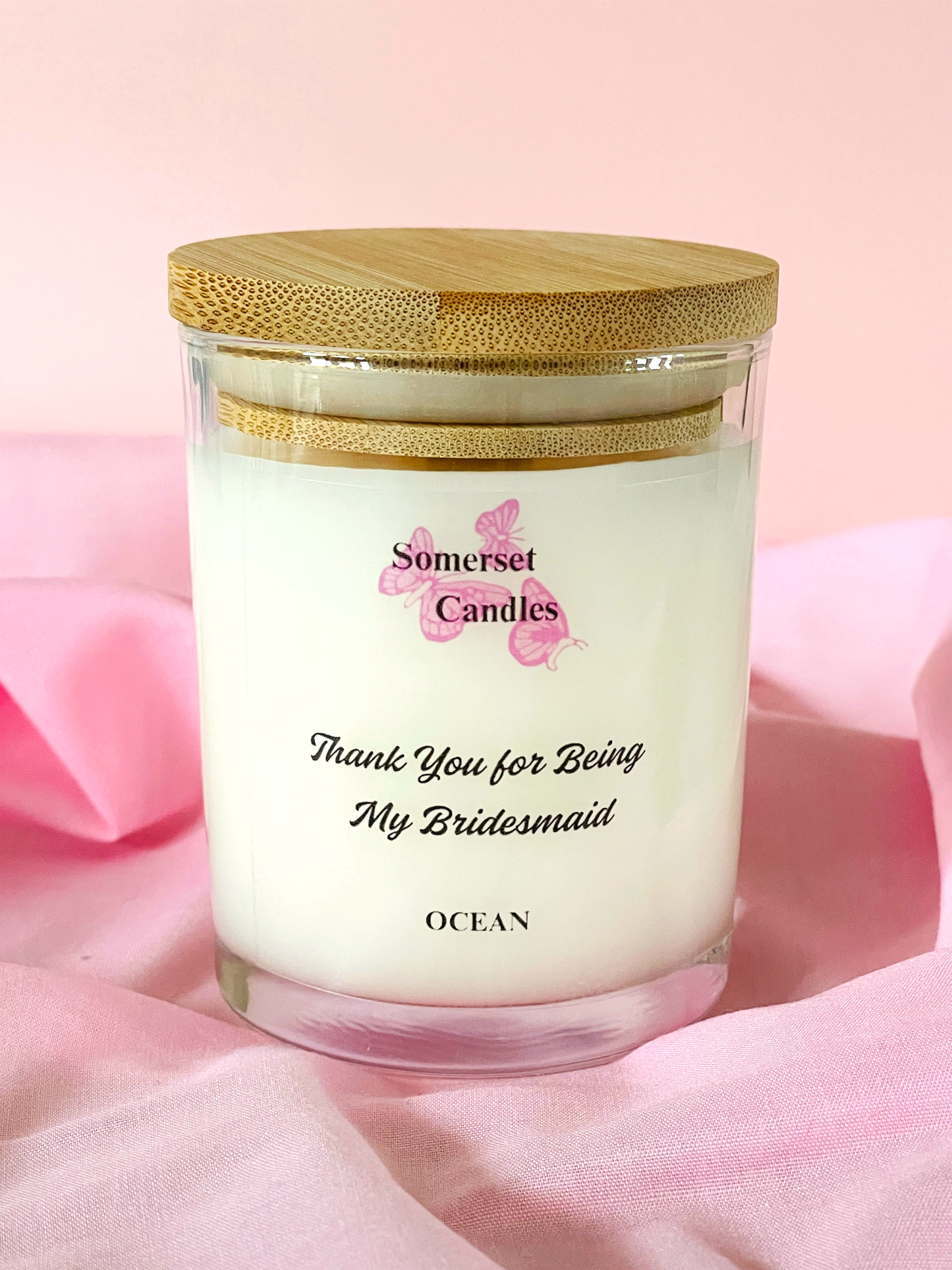 Scented Candle in a glass jar with a wooden lid on a pink background, featuring the 'Somerset Candles' brand.