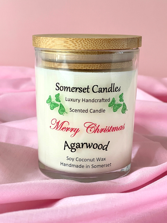 Somerset Candles Merry Christmas Agarwood candle on a pink fabric background