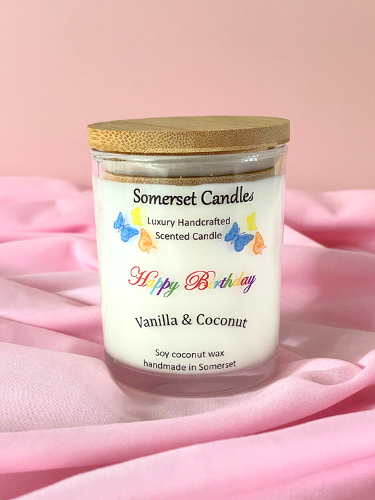 Somerset Candles birthday candle with vanilla and coconut scent on a pink fabric background