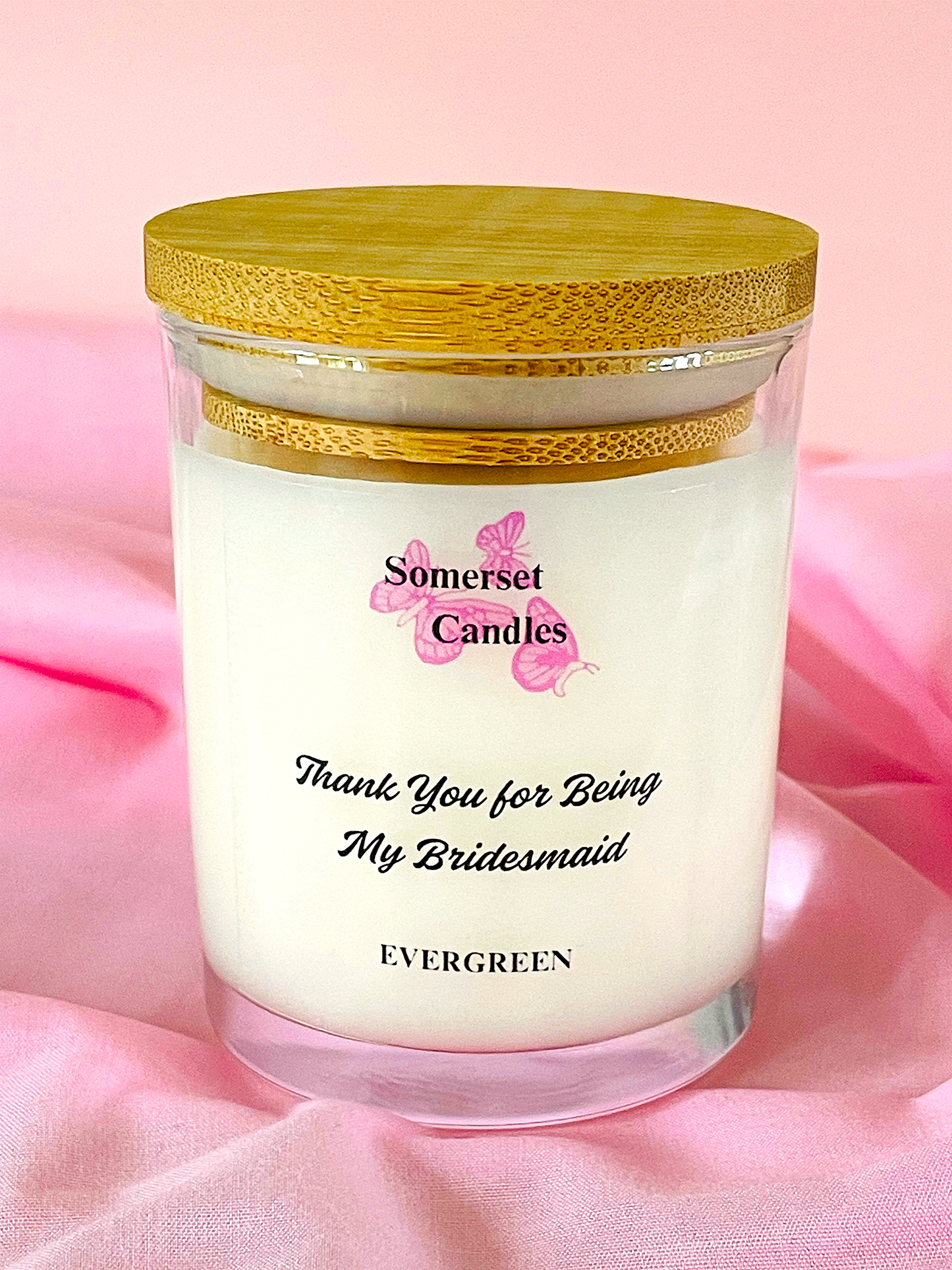 Candle with 'Somerset Candles' branding on a pink fabric background