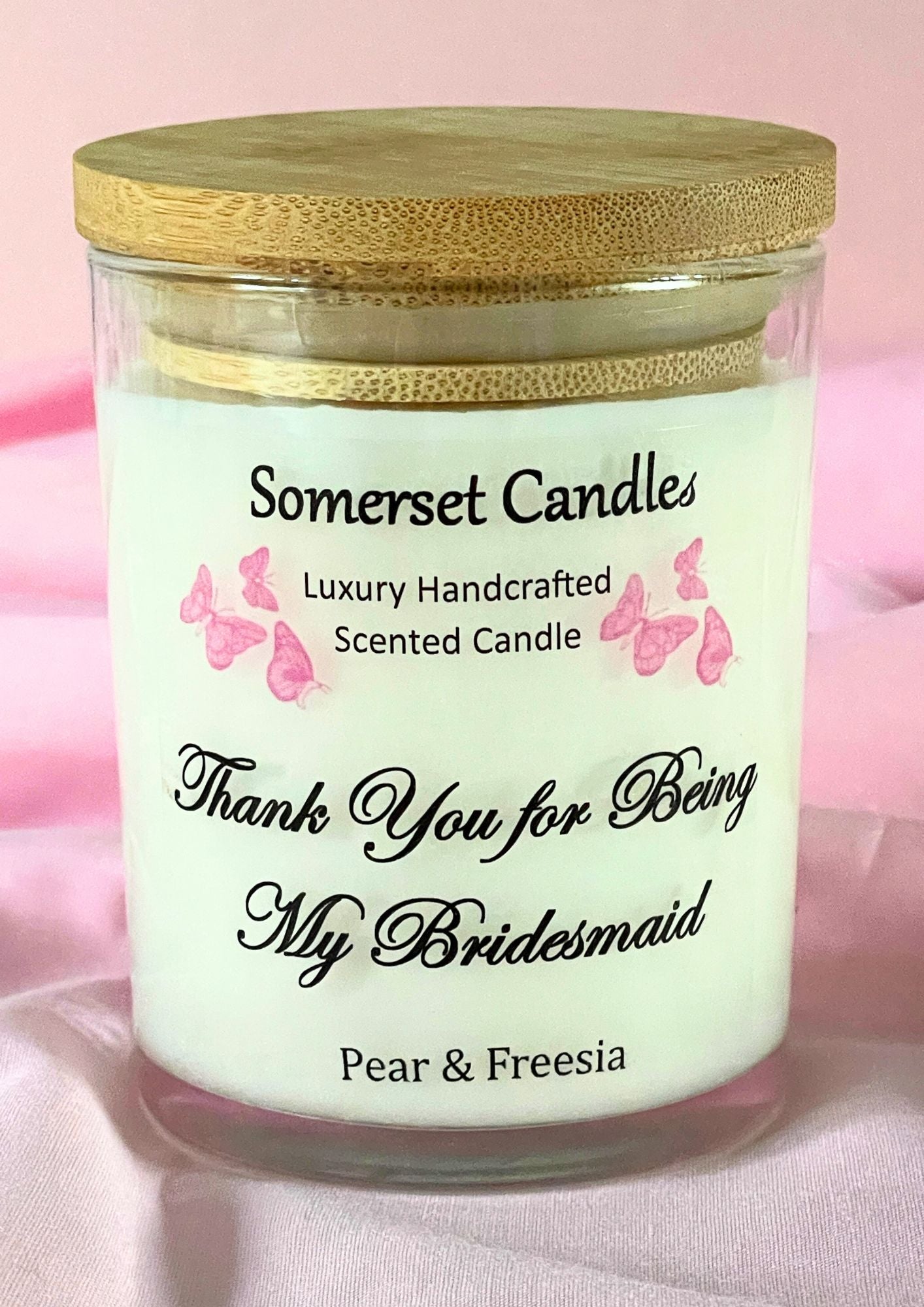 Candle with 'Somerset Candles' branding and text on a pink background