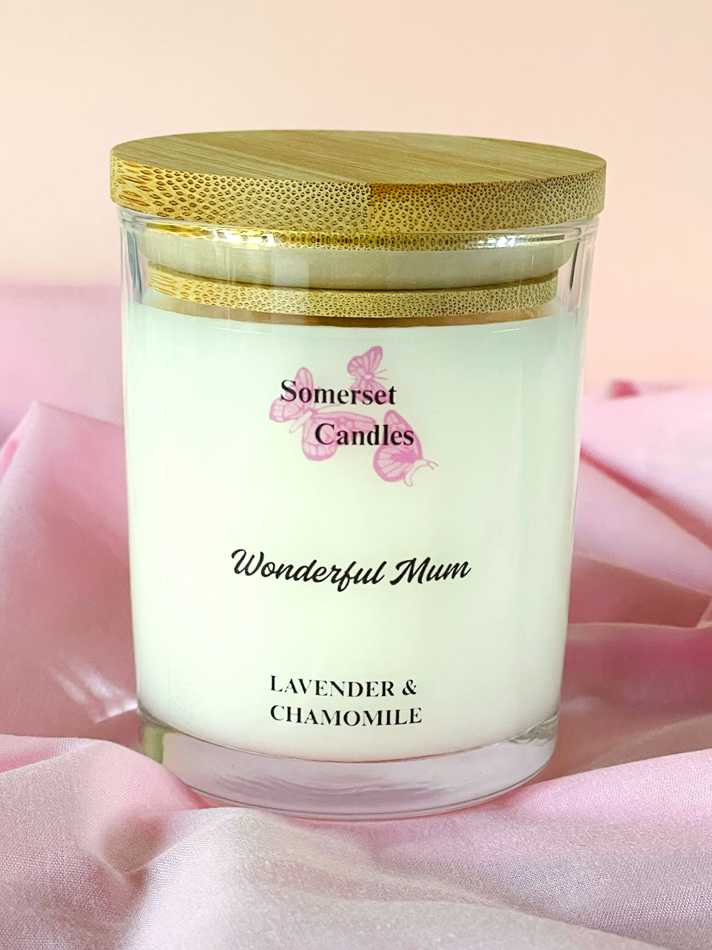 Candle with 'Somerset Candles' branding on a pink fabric background