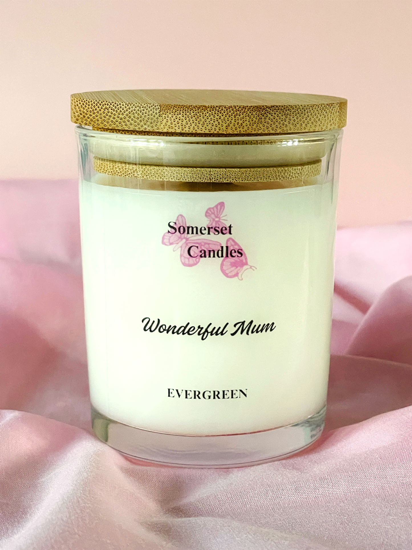 Candle jar labeled 'Wonderful Mum' by Somerset Candles on a pink fabric background