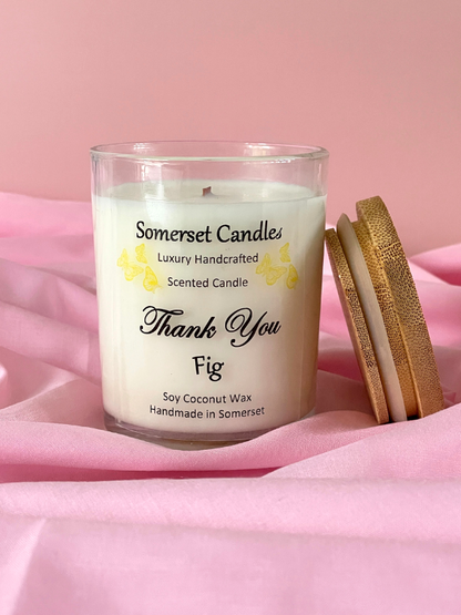Somerset Candles scented candle with wooden Wick Trimmer on pink fabric background