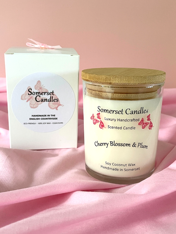 Somerset Candle with cherry blossom and plum scent on a pink fabric background