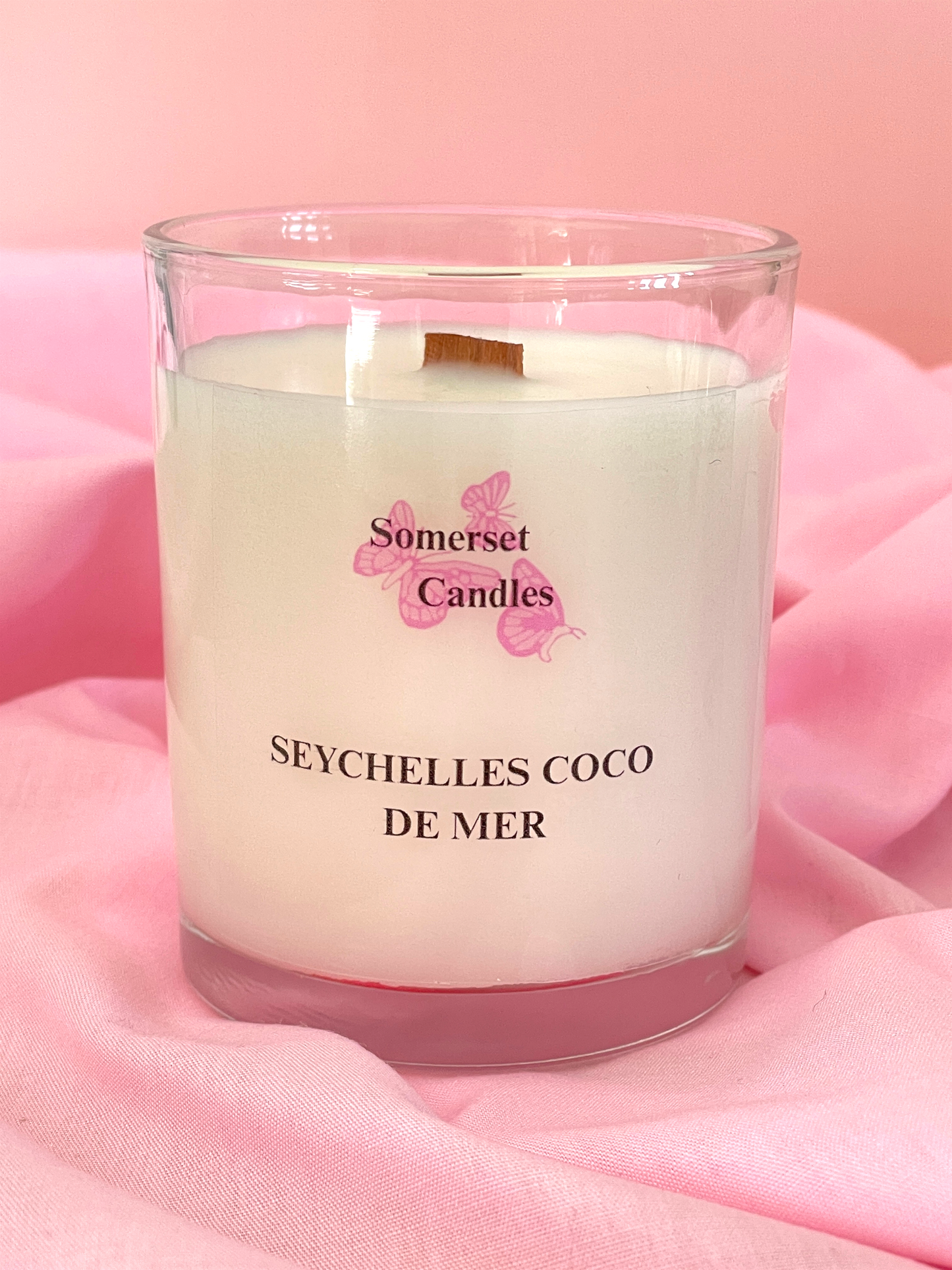 Somerset Candles Seychelles Coco de Mer candle on a pink fabric background