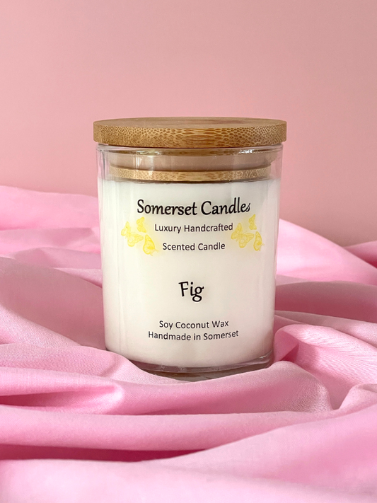 Somerset Candles Fig scented candle with a wooden lid on pink fabric