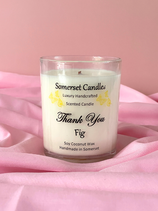 Somerset Candles scented candle with 'Thank You' and 'Fig' text on a pink fabric background