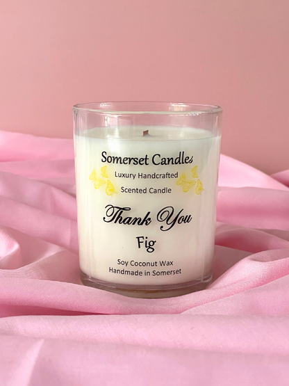 Somerset Candles scented candle with 'Thank You' and 'Fig' text on a pink fabric background