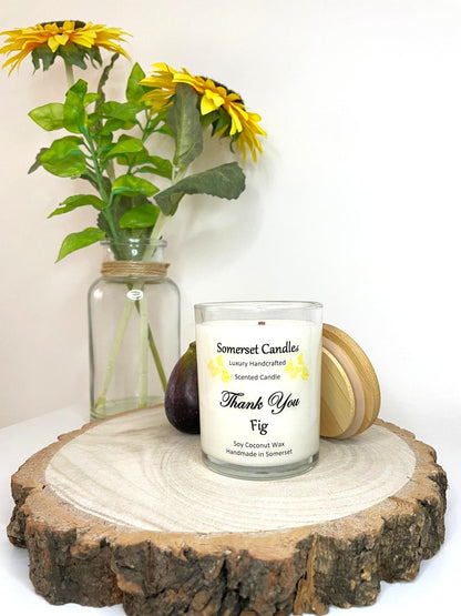 White soy candle in a 7oz clear glass jar with a natural wooden lid. The candle is made from a soy-coconut blend and scented with ripe fig. Above the scent name on the label, several yellow butterflies are displayed, adding a romantic touch. Clean, minimalist design ideal for gifts, home decor or self-care.