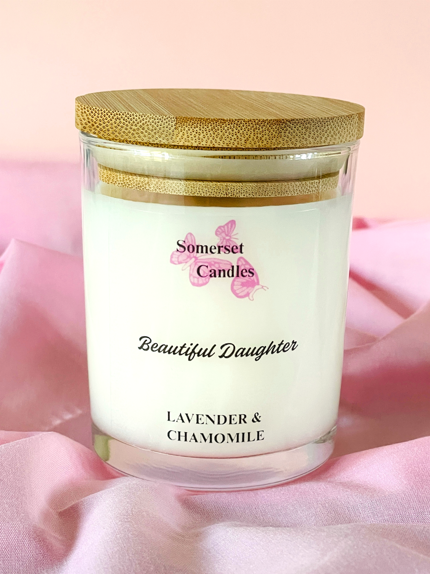 Somerset Candles 'Beautiful Daughter' lavender and chamomile candle on a pink fabric background