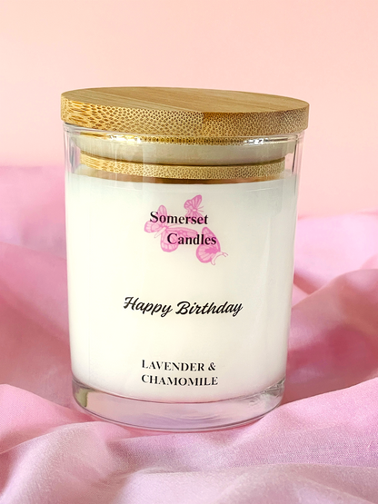 Scented Candle with a wooden lid labelled 'Somerset Candles' on a pink background