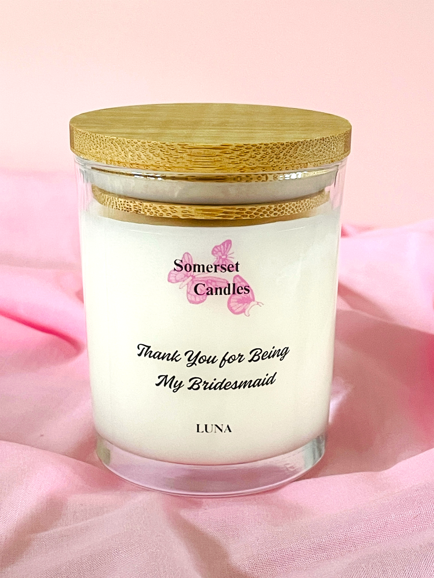 Clean Burning Candle in a 7oz glass jar with a wooden lid on a pink background, featuring 'Somerset Candles' branding.