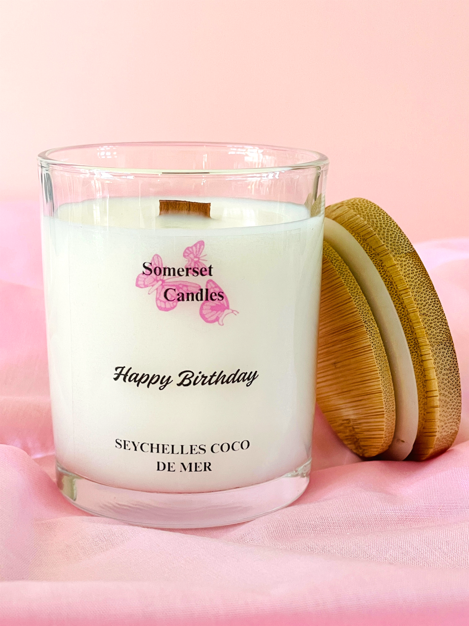 Somerset Candles 'Happy Birthday' candle with wooden lid on a pink background