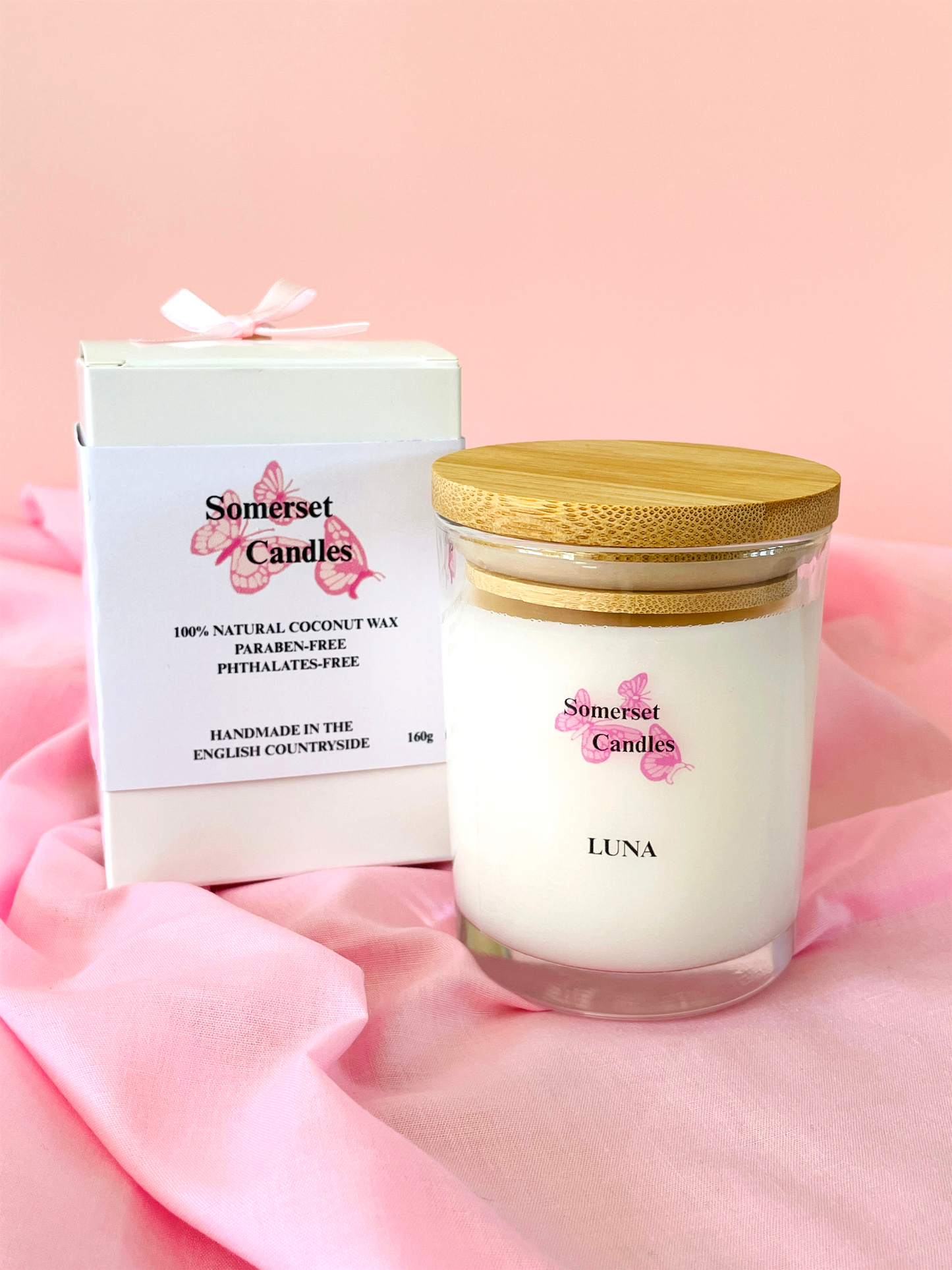 Somerset Candles Luna candle with packaging on a pink fabric background