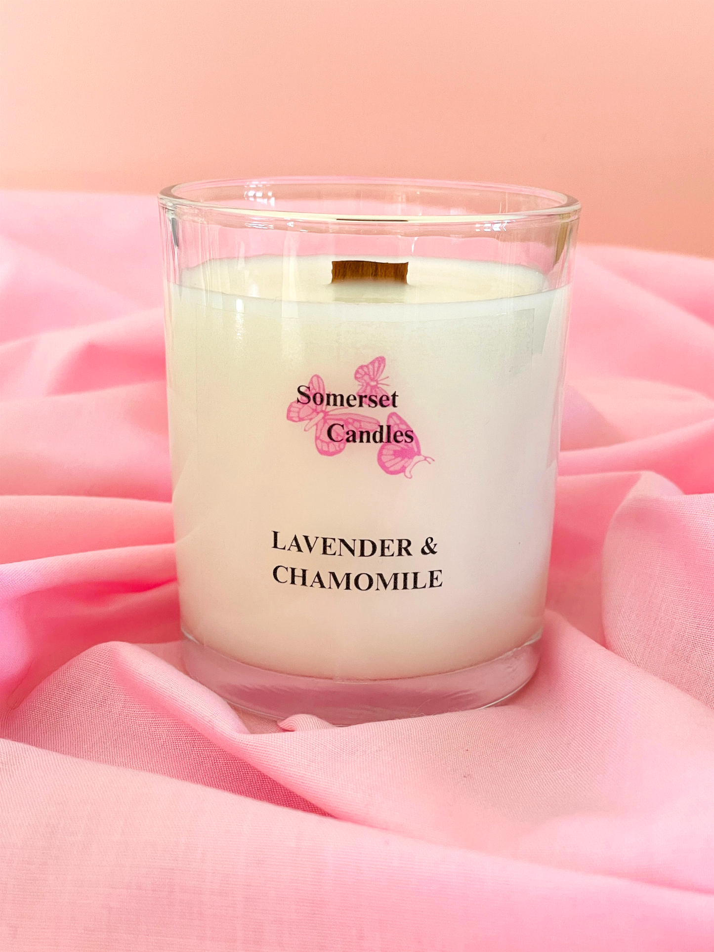 Somerset Candles lavender and chamomile candle on pink fabric with a pink background