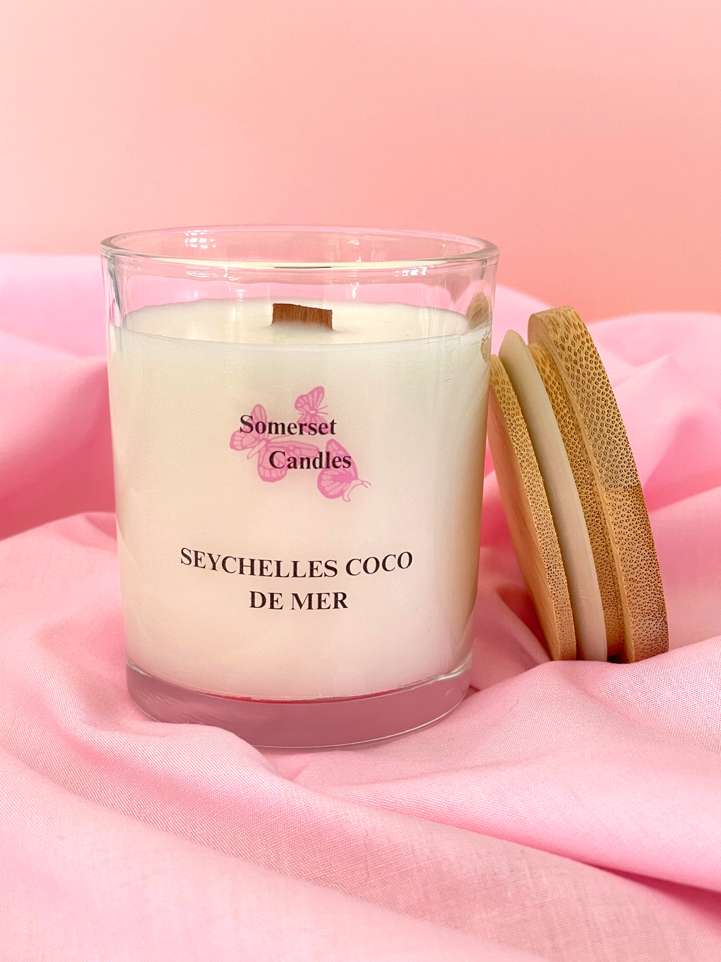 Somerset Candles Seychelles Coco de Mer candle on a pink fabric background