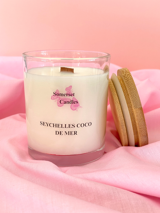 Somerset Candles Seychelles Coco de Mer candle on a pink fabric background