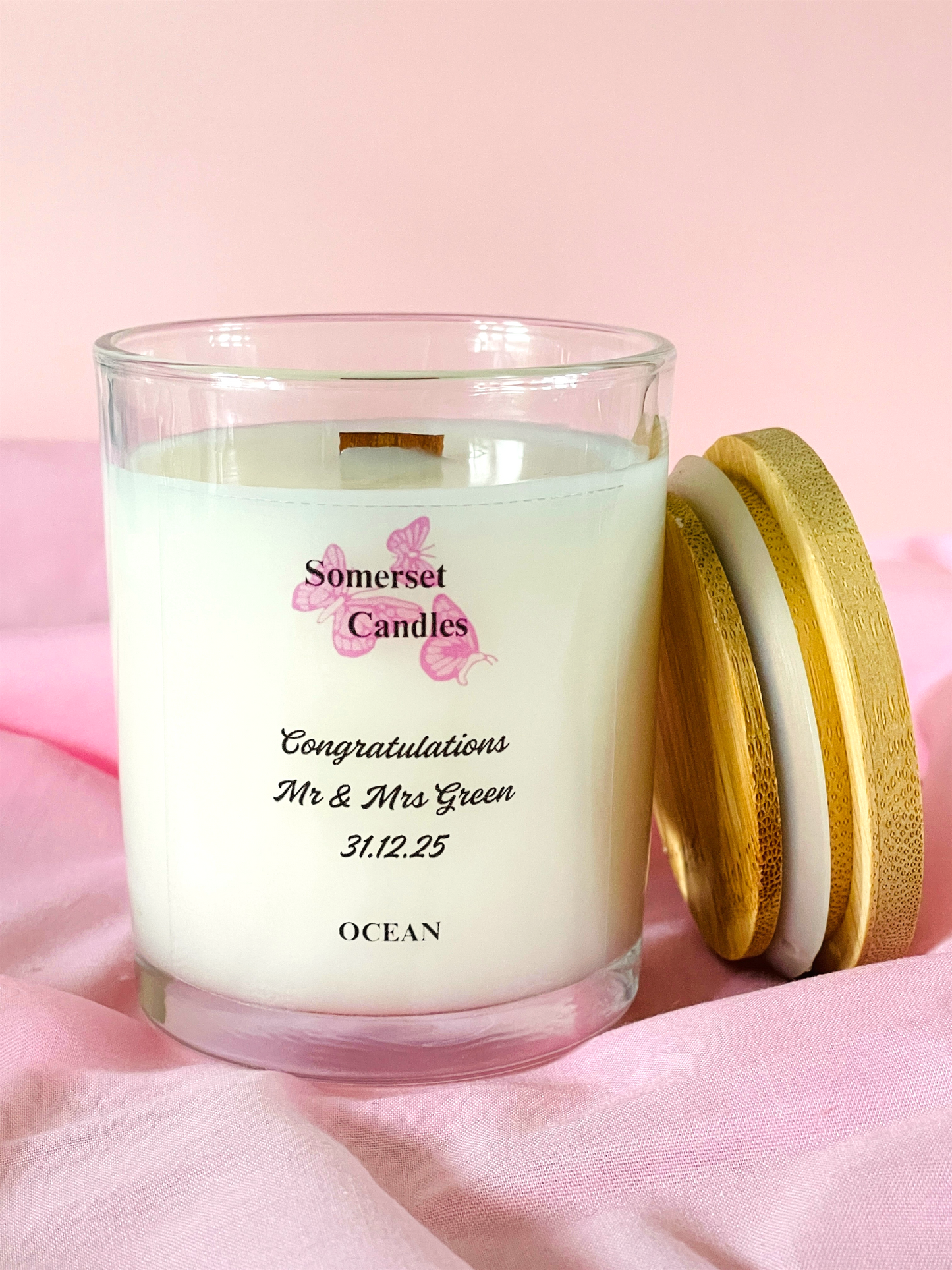 Personalised candle with 'Somerset Candles' branding on a pink background
