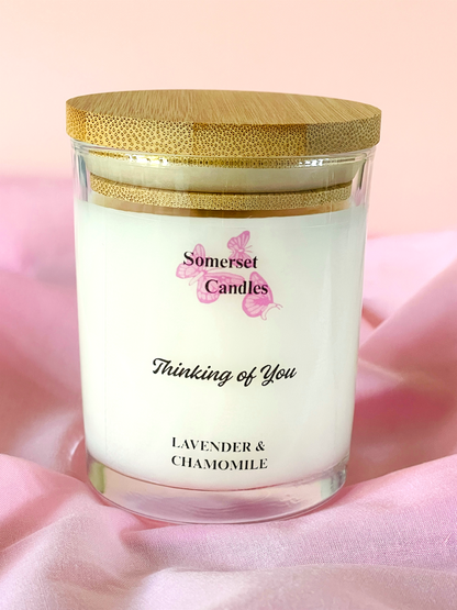 Somerset Candles 'Thinking of You' lavender and chamomile candle with a wooden lid on a soft pink background.
