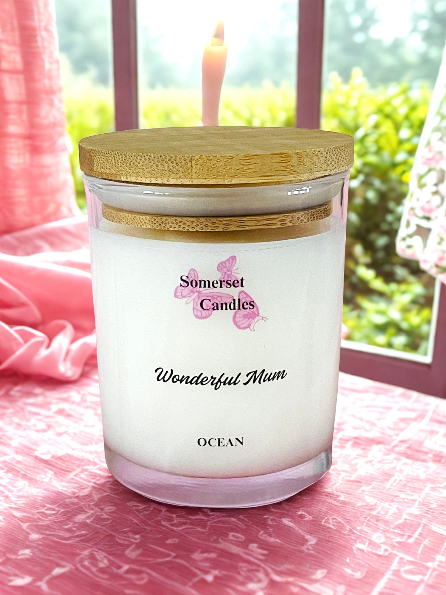 Somerset Candles 'Wonderful Mum' ocean-scented candle with a wooden lid on a pink surface.