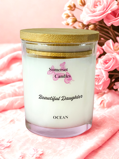 Somerset Candles 'Beautiful Daughter' candle with wooden lid on a pink floral background