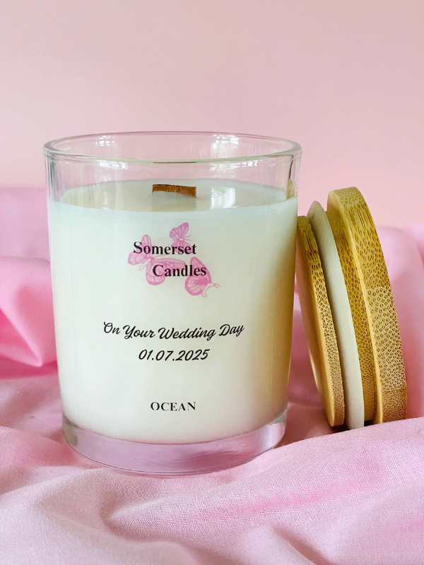 Personalised candle with 'Somerset Candles' branding on a pink fabric background