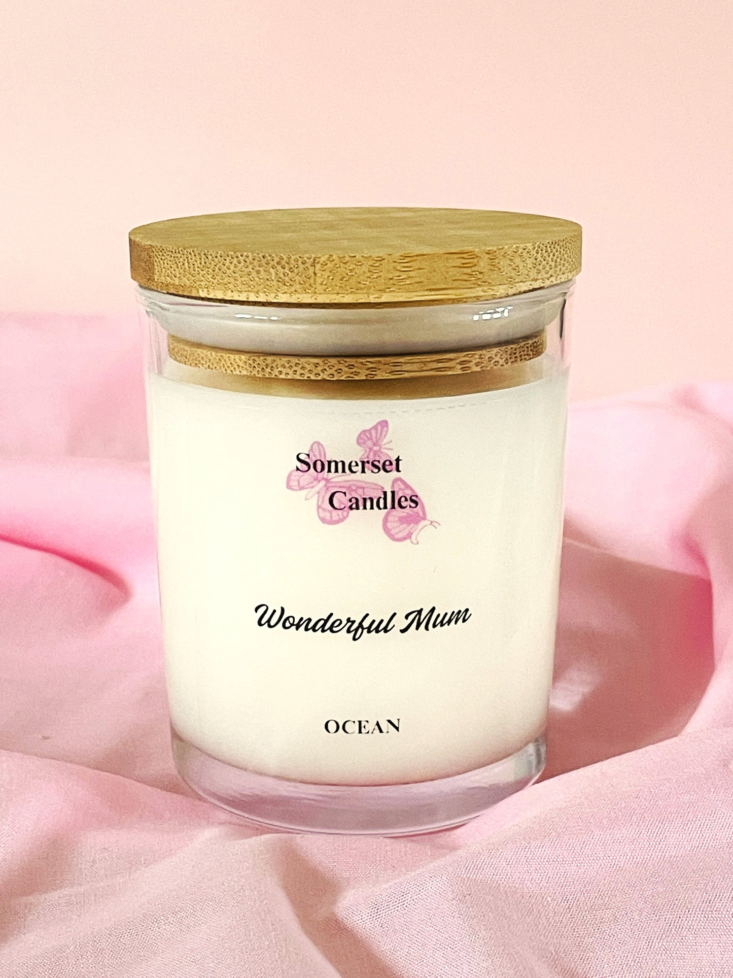 Somerset Candles 'Wonderful Mum' ocean-scented candle with a wooden lid on a pink background