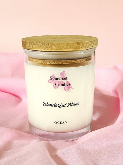 Somerset Candles 'Wonderful Mum' ocean-scented candle with a wooden lid on a pink background