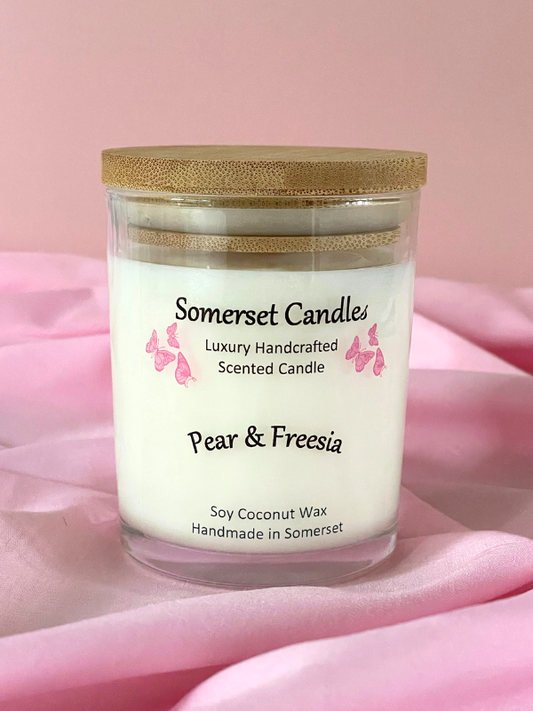 Somerset Candles Pear & Freesia candle on a pink fabric background