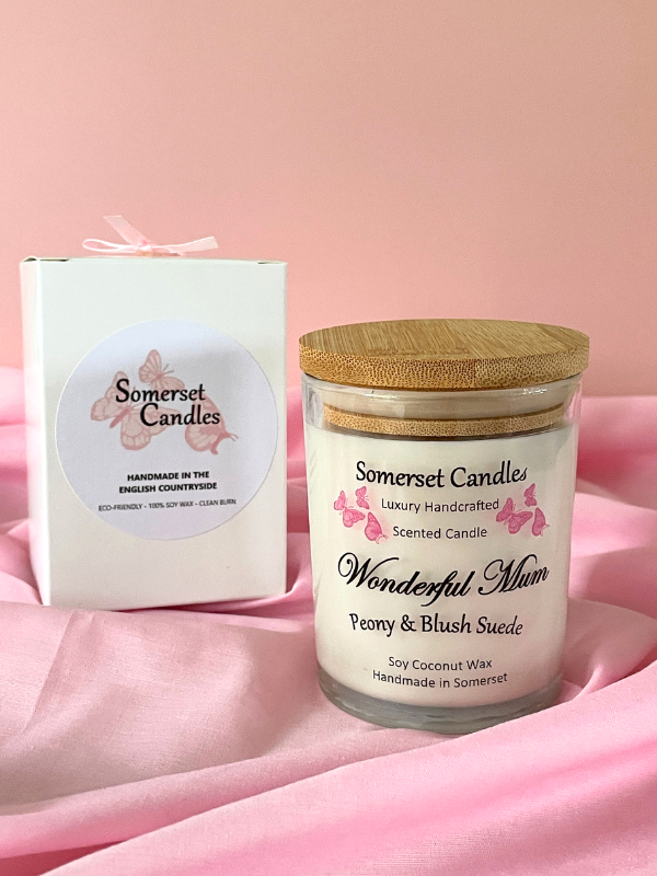 Somerset Candles jar with wooden lid and packaging on a pink fabric background