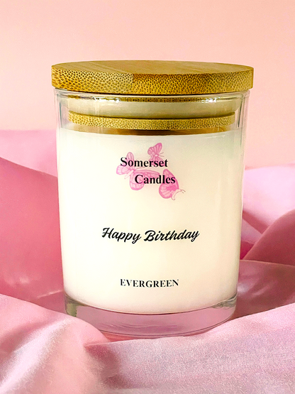 Somerset Candles 'Happy Birthday' candle with gold lid on pink fabric background