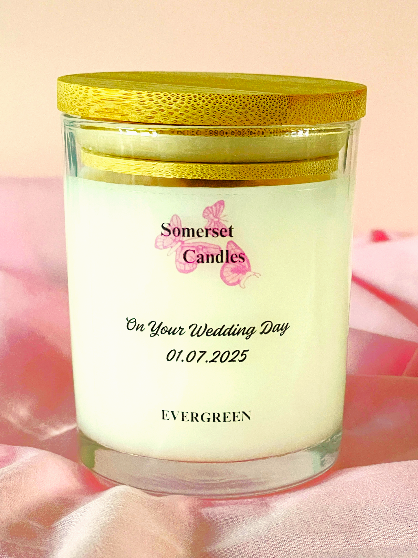 Personalised candle with 'Somerset Candles' branding and text on a soft pink background