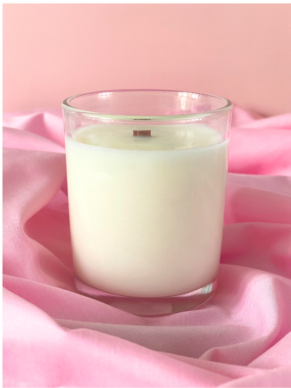 Glass candle on pink fabric with a soft pink background