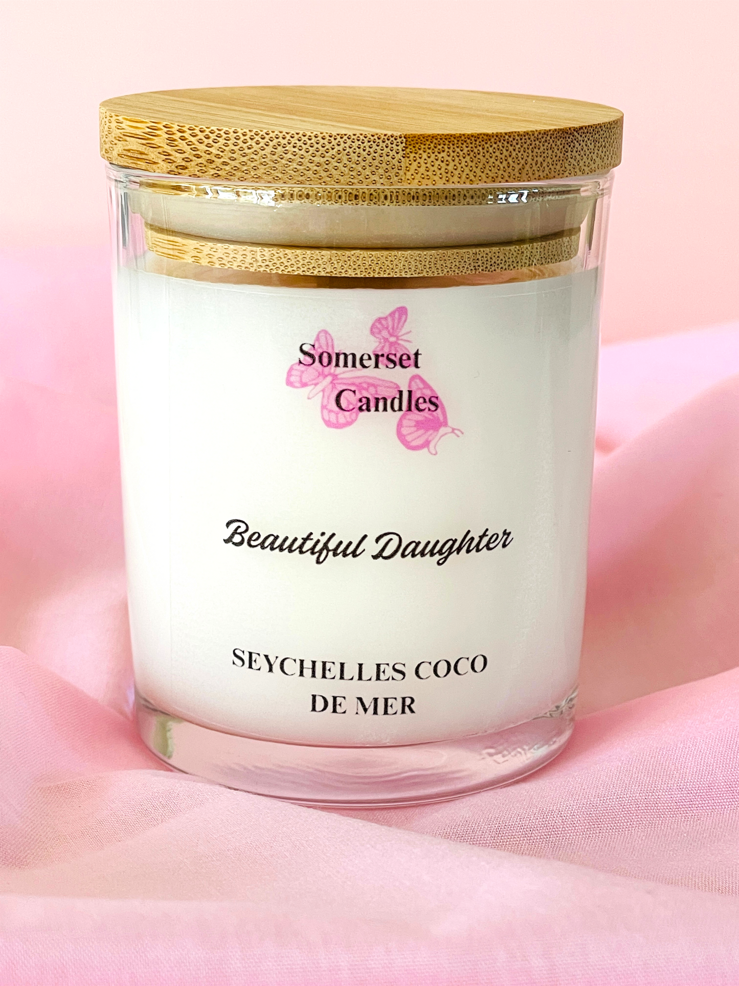 Somerset Candles 'Beautiful Daughter' Seychelles Coco de Mer candle on a pink fabric background