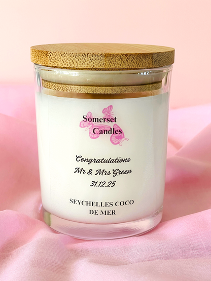 Personalised candle with wooden lid on a pink background, featuring 'Somerset Candles' branding.