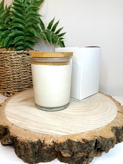 White soy candle in a 7oz clear glass jar with a natural wooden lid. The candle is made from a soy-coconut blend and a variety of fresh fragrances. The candle has no label. The candle is presented with a plain white gift box. Clean, minimalist design ideal for gifts, home decor or self-care.