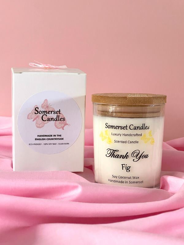 Somerset Candles scented candle and packaging on a pink fabric background
