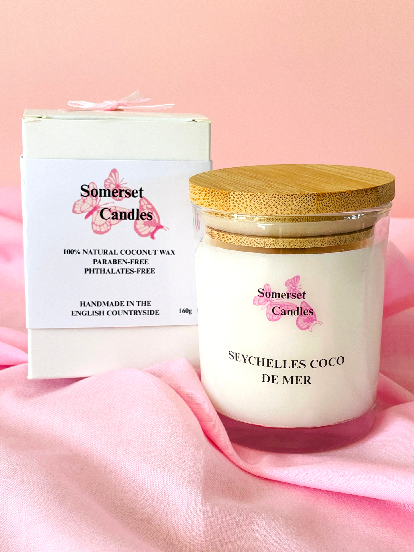 Somerset Candles Seychelles Coco de Mer candle with packaging on a pink background