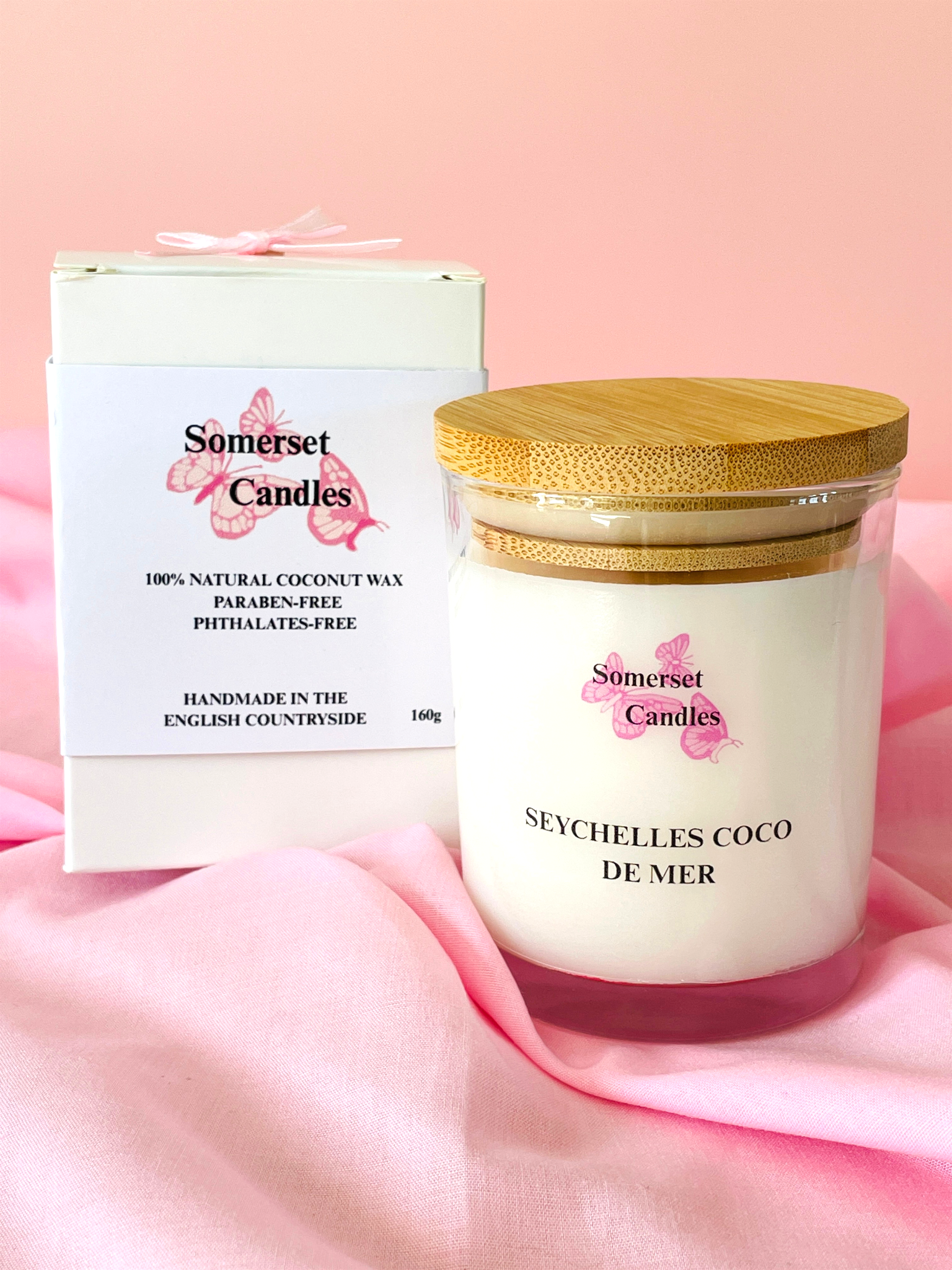Somerset Candles Seychelles Coco de Mer candle with packaging on a pink background
