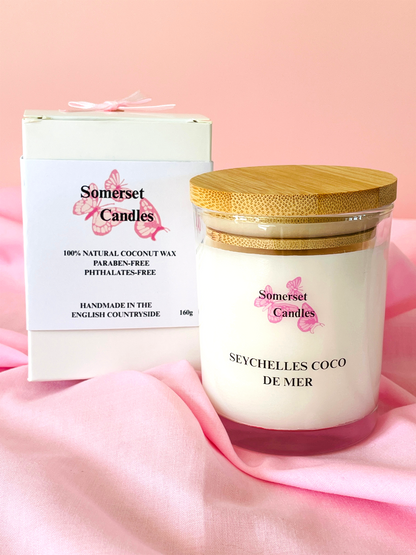 Somerset Candles Seychelles Coco de Mer candle with packaging on a pink background
