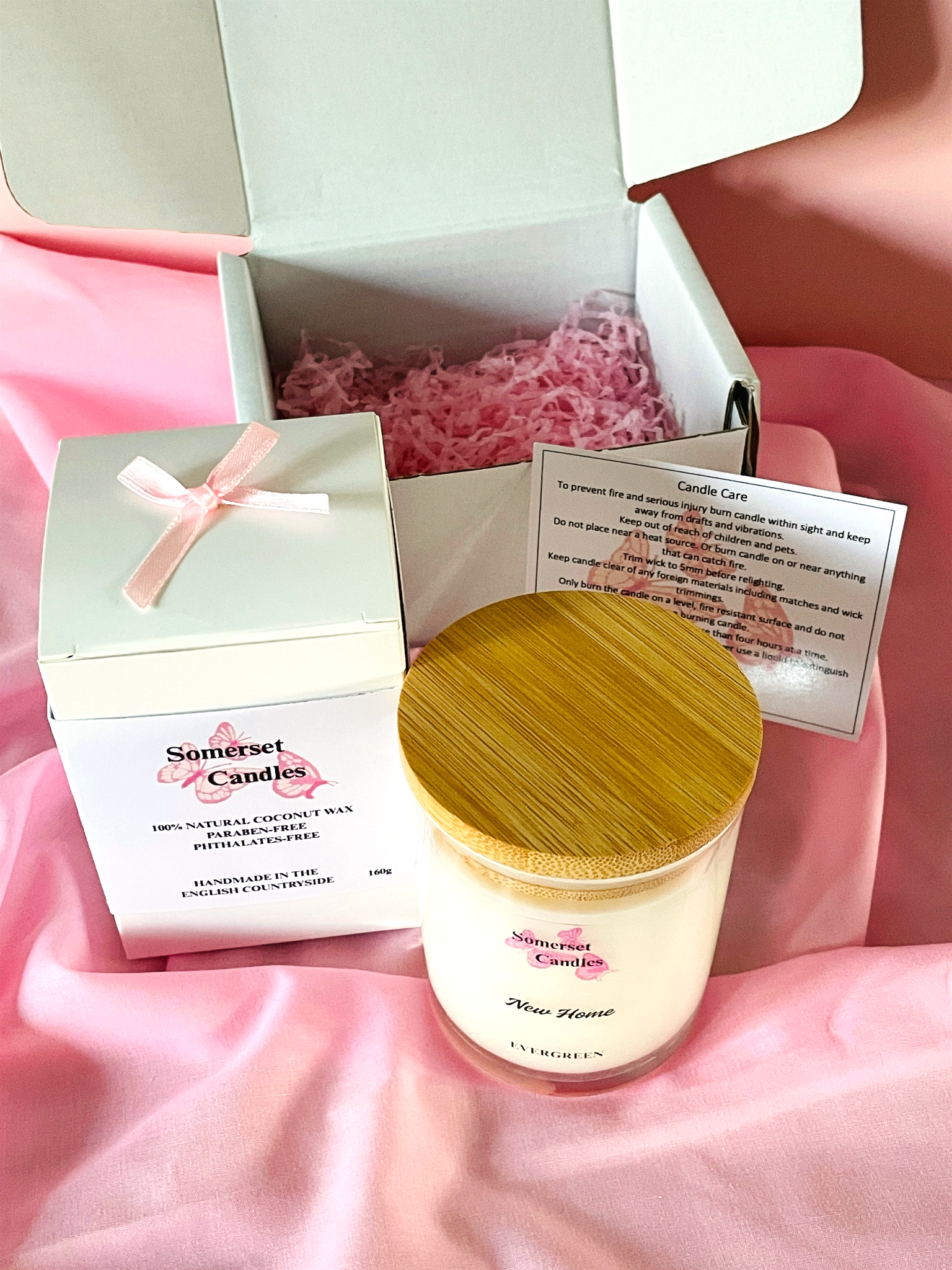 Somerset Candles candle with wooden lid and packaging on a pink background