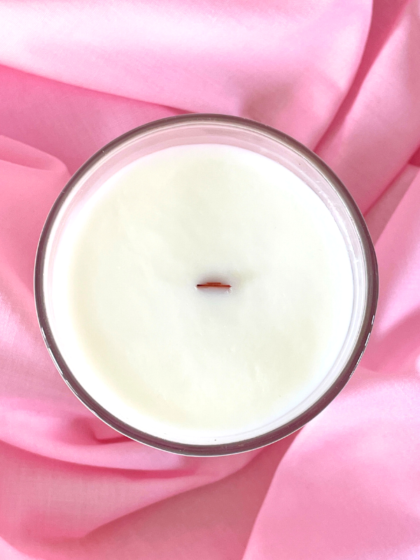 Candle in a glass jar on pink fabric