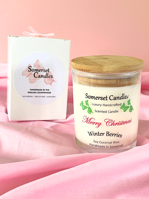 Somerset Candles 'Merry Christmas Winter Berries' candle with packaging on a pink background