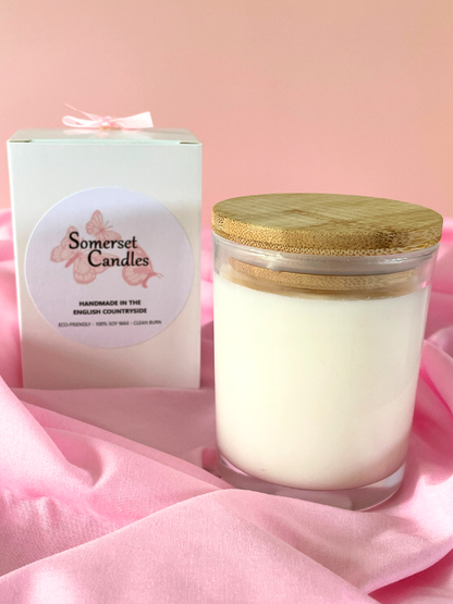 Somerset Candles jar with wooden lid on a pink fabric background