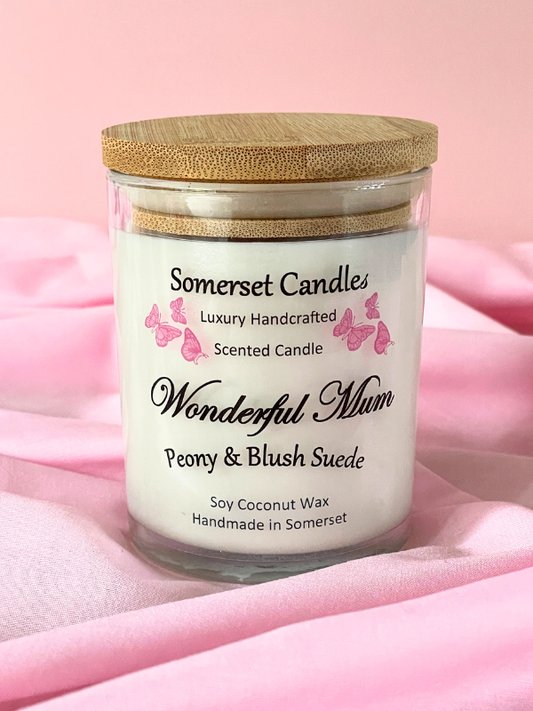 Somerset Candles scented candle with wooden lid on a pink fabric background