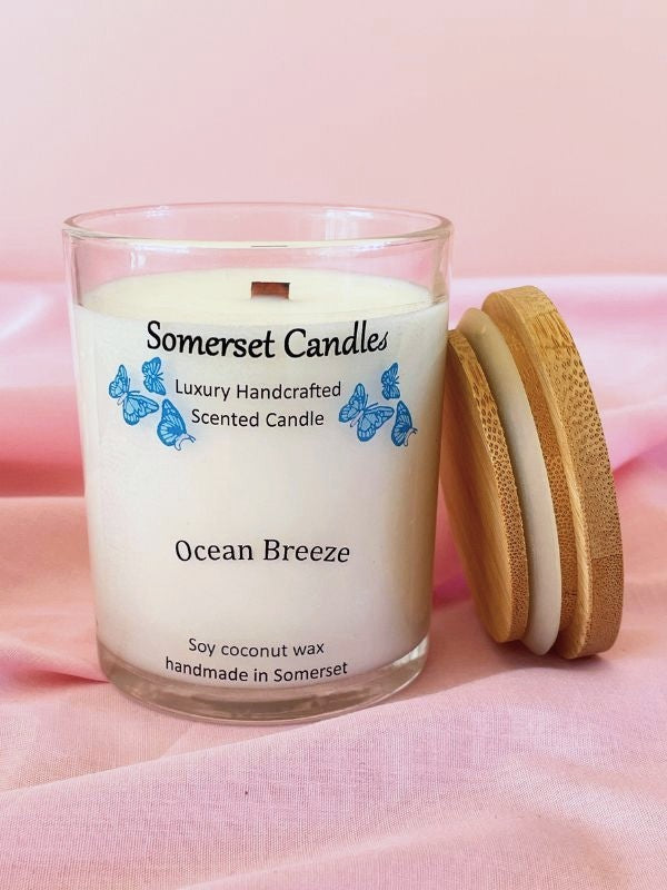 Somerset Candles Ocean Breeze candle with wooden lid on a pink fabric background